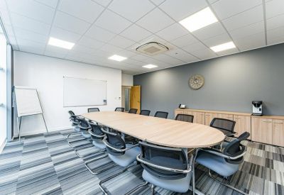 Professional meeting room with a wall-mounted clock and light wood cabinetry.