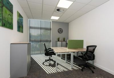 Small private office with wood-finish desks and a green privacy screen.