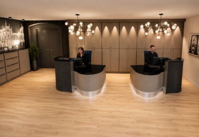 Elegant reception area with two minimalist curved desks and warm accent lighting.