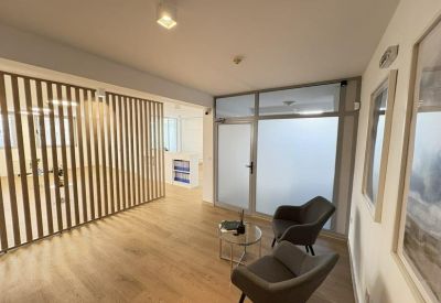 Lounge area with comfortable armchairs and a decorative wooden slat wall.