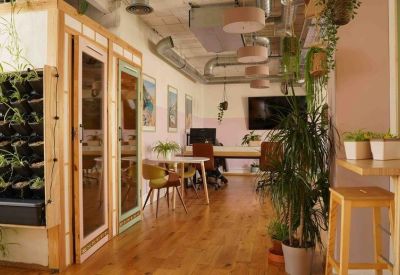 Modern coworking area with private glass-fronted booths and a standing breakfast bar.
