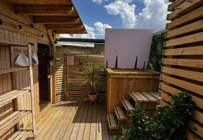 Outdoor wellness area featuring a wooden sauna building and a plunge pool.