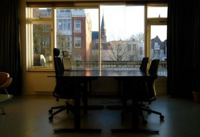 Meeting room featuring a long dark table and a large window overlooking the city skyline.
