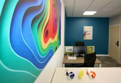 Modern office suite with a vibrant abstract feature wall and dark teal accents.