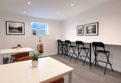 Communal dining area with tables, chairs, and wall art.