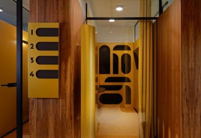 Modern corridor with yellow signage showing room numbers 1 through 4 and wood paneling.