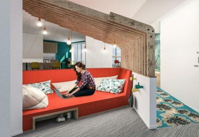 Modern lounge area featuring a person on a red cushioned bench beneath a unique wooden canopy.