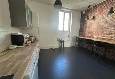 Breakout area with a wood-topped counter and a rustic red brick feature wall.