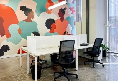 Bright reception area with red lounge chairs and minimalist white desk.