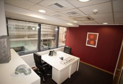 Private office featuring a white desk against a bold red feature wall.