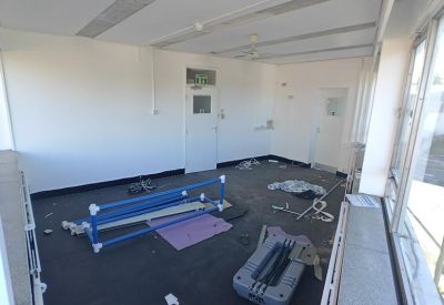 Spacious top-floor office space with dark flooring and large windows overlooking the street.