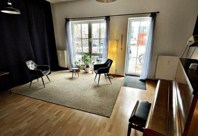 Spacious creative office at 177, Prenzlauer Promenade with wood floors, a piano, and large windows.