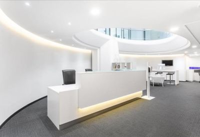 Modern white reception desk under a circular architectural skylight.