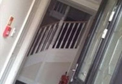 Entrance hallway with black door and white staircase.