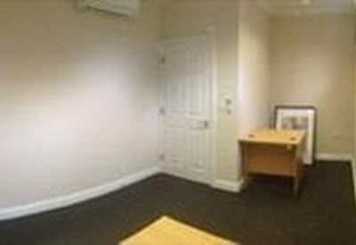 Compact office space with neutral walls and a small wooden desk.