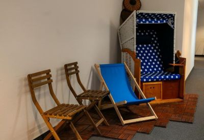 Quirky indoor seating area with wooden chairs and a traditional beach chair.