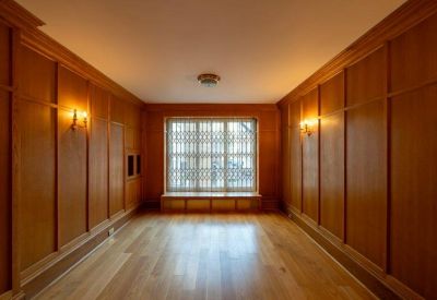 Warm wood-paneled meeting room with a large window and hardwood floors.