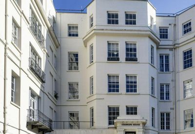 Exterior view of the white facade and arched entrance of 18 Stanhope Place.