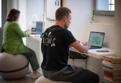 Coworking space featuring ergonomically designed exercise ball seating and white desks.