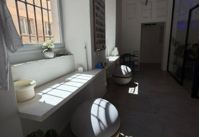 Bright hallway with white walls, minimalist sphere seating, and a large window with natural light.