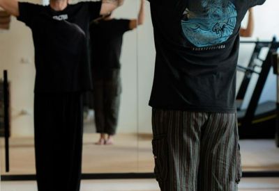 Fitness professional guiding a client through exercises in a mirrored studio.