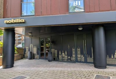 Branded entrance with black pillars and decorative skyline graphics on the glass.