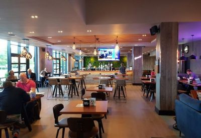 Spacious communal lounge and cafe at 186 Otley Road, Headingley with warm lighting and wooden tables.