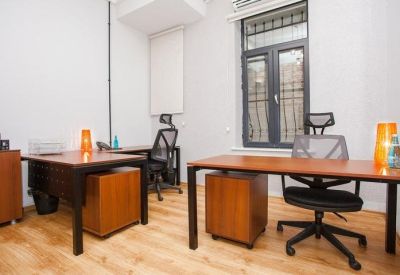 Modern dual-desk office space with ergonomic chairs and orange desk lamps.