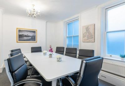 Professional meeting room at 19-21, Christopher Street featuring a large white table and black leather chairs.
