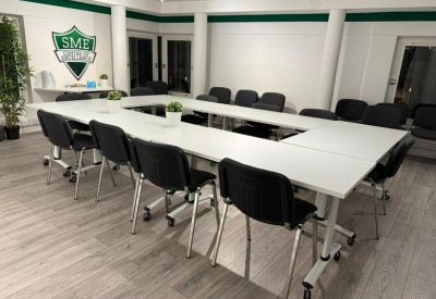 Spacious boardroom at 19 Main Street, Ponteland, featuring a U-shaped table and branded SME shield wall logo.