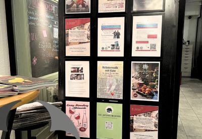 Information board in a black frame displaying various community posters and event flyers.