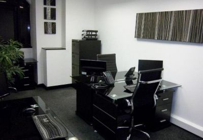 Private office suite with black glass desks and ergonomic chairs.