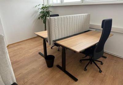 Modern sit-stand workstations featuring acoustic privacy screens and ergonomic chairs.