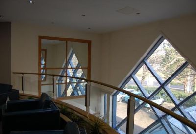 Modern mezzanine lounge area overlooking a large diamond-shaped window.