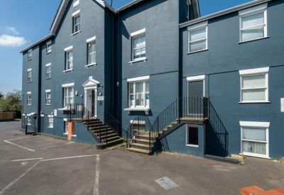 Exterior view of the blue painted facade of 2, Cambridge Road with staircase entrance.