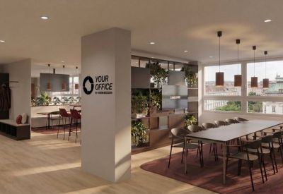 Large communal coworking space with wooden floors, indoor plants, and a long dining table.
