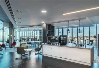 Spacious communal lounge with modern seating, a central bar, and floor-to-ceiling windows.