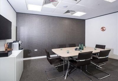 Professional meeting room featuring a grey accent wall and coffee station.