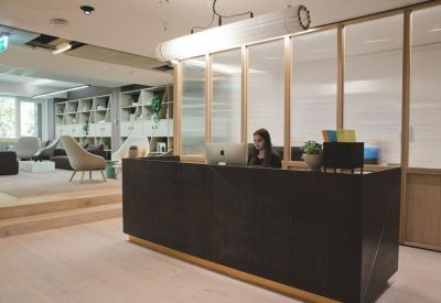 Modern reception desk with wooden wall panels and a soft overhead light.