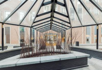 Indoor courtyard walkway featuring a glass pyramid roof and planter beds.
