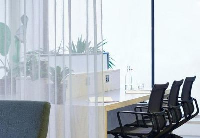 Modern open-plan workspace with black ergonomic chairs and stylish minimalist lighting.