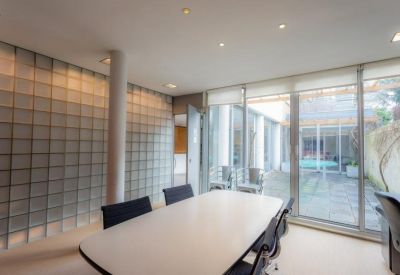 Bright conference room with a glass wall and modern lighting.