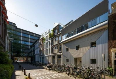 Street view with buildings, glass facades, and parked bicycles.