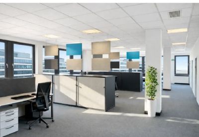Bright open-plan workspace with colorful acoustic hanging panels and a large potted plant.
