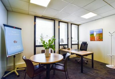 Private office featuring a round consultation table and flipchart.