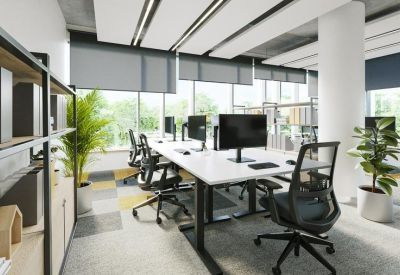 Bright open-plan office with white desks, ergonomic chairs, and large windows.
