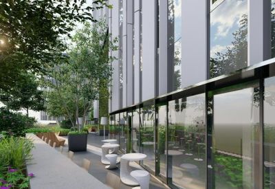 Outdoor walkway alongside the building's glass facade with small tables and seating.