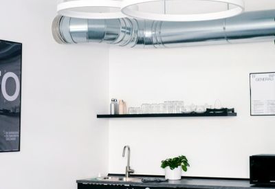 Sleek black kitchen and dining area with circular pendant lighting.