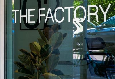 Window decal with branding and green plants in the background.