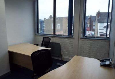 Private office space with two desks and view of surrounding neighborhood.